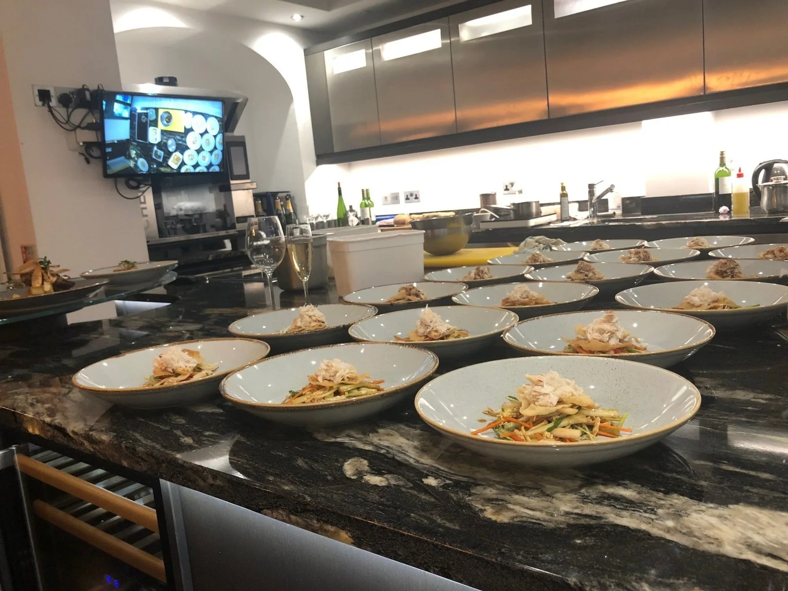 A line of plates being prepared beside the demonstration kitchen at 7B.